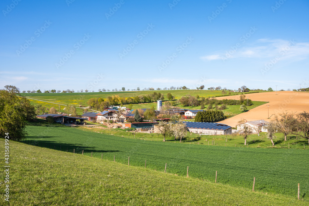 Frühlingslandschaft mit modernem Aussiedlerhof mit Solardächern Frühlingslandschaft mit modernem Aussiedlerhof mit Solardächern