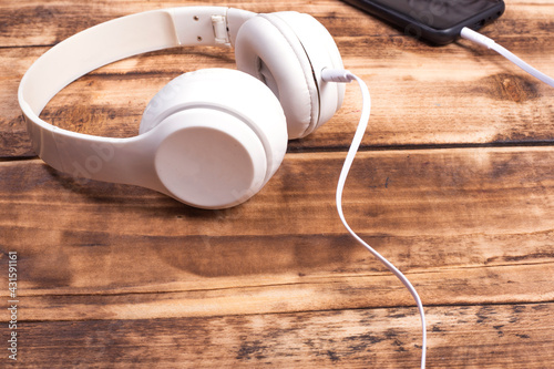white headphones on wooden background