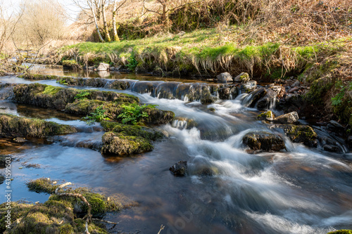 Fototapeta Naklejka Na Ścianę i Meble -  Long exposure of the Weir Water river  flowing through the valley at Robbers Bridge in Exmoor National Park