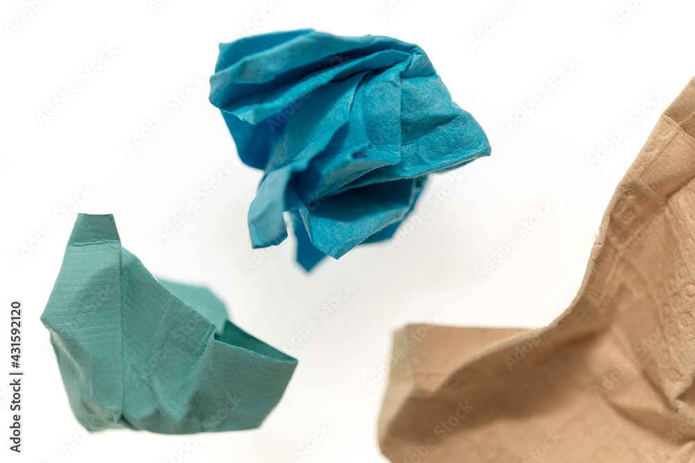 crumpled cerulean blue, teal green, and sand brown patterned and textured paper on white