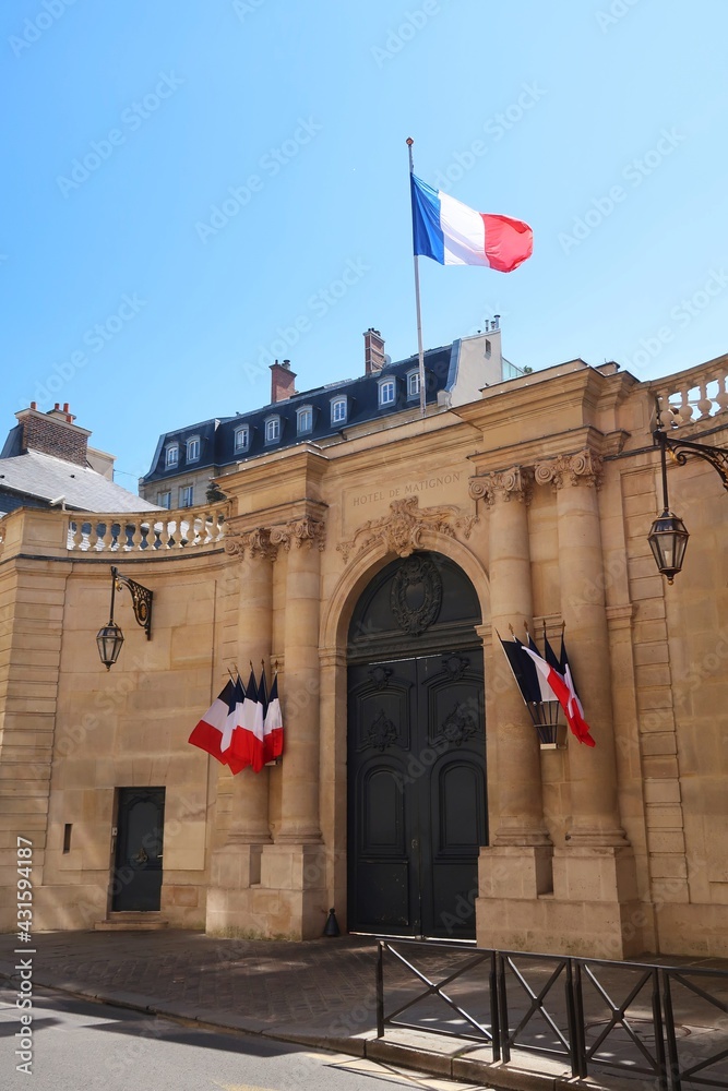 Portail d'entrée de l'hôtel de Matignon, palais de résidence officielle du Premier Ministre français, rue de Varenne à Paris, surmonté d'un drapeau français (France) - obrazy, fototapety, plakaty 