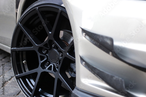 Close up of a wheel of a sports car. Black car rim with low profile rubber.