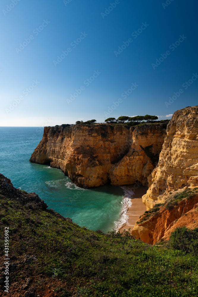 View of a small secluded beach surrounded by cliffs in Algarve, Portugal