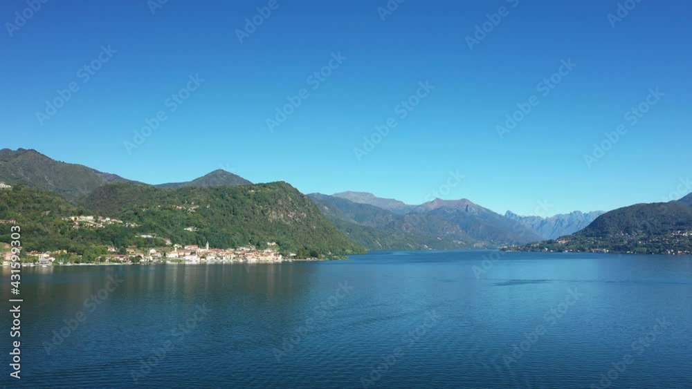 Les berges du lac d'Orta entourée des montagnes et forêts verdoyantes dans le Piémont, vers les Alpes, en Italie, en drone, à l'automne lors d'une journée sous le Soleil.