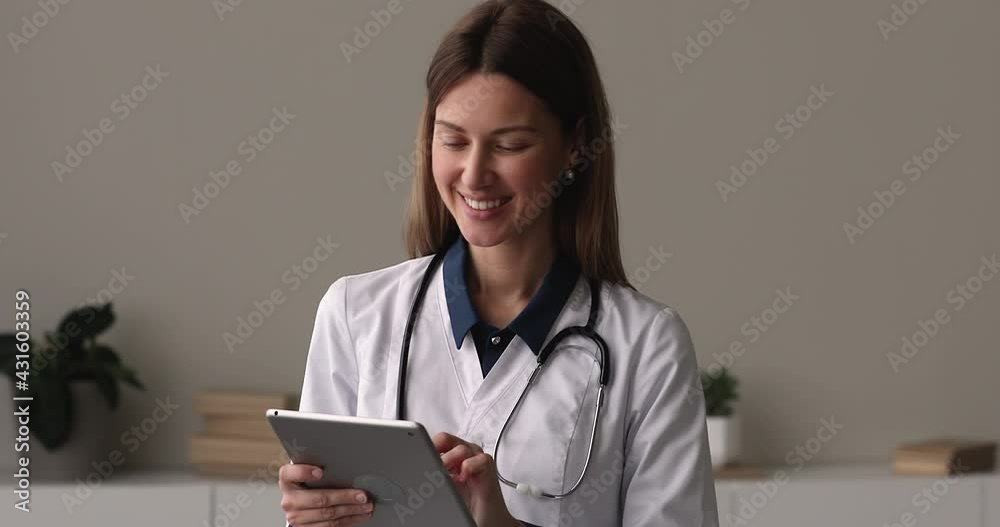 Female doctor wear white coat stethoscope on neck stand in office with tablet device working typing on gadget, check online agenda. Modern tech, professional mobile apps for medical workers concept Female doctor wear white coat stethoscope on neck stand in office with tablet device working typing on gadget, check online agenda. Modern tech, professional mobile apps for medical workers concept