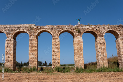 The 200 year old Ottoman aqueduct  supplied water from Cabri springs to Acco  western Galilee  Israel. Middle aged female posing at the upper line of the aqueduct.