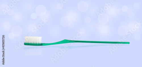 turquoise plastic toothbrush on blue background