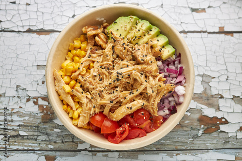 Quadro su tela Top-view view of an avocado chicken poke and cherry tomatoes in a bowl
