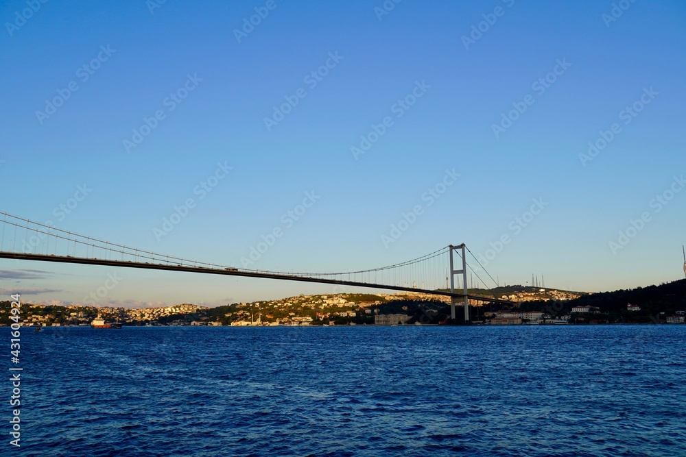 Tourist boats sail under the bridge in Istanbul. Traveling on the Bosphorus. Panoramic view, View of the First Bosphorus Bridge sailling Bosporus. Tourist boats sail under the bridge in Istanbul. Traveling on the Bosphorus. Panoramic view, View of the First Bosphorus Bridge sailling Bosporus.