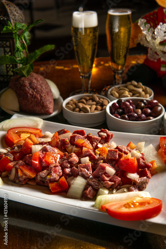 Traditional Middle Eastern food. Lebanese food. Arabian raw meat salad, berr glass, kibbeh, tomatoes, christmas decoration