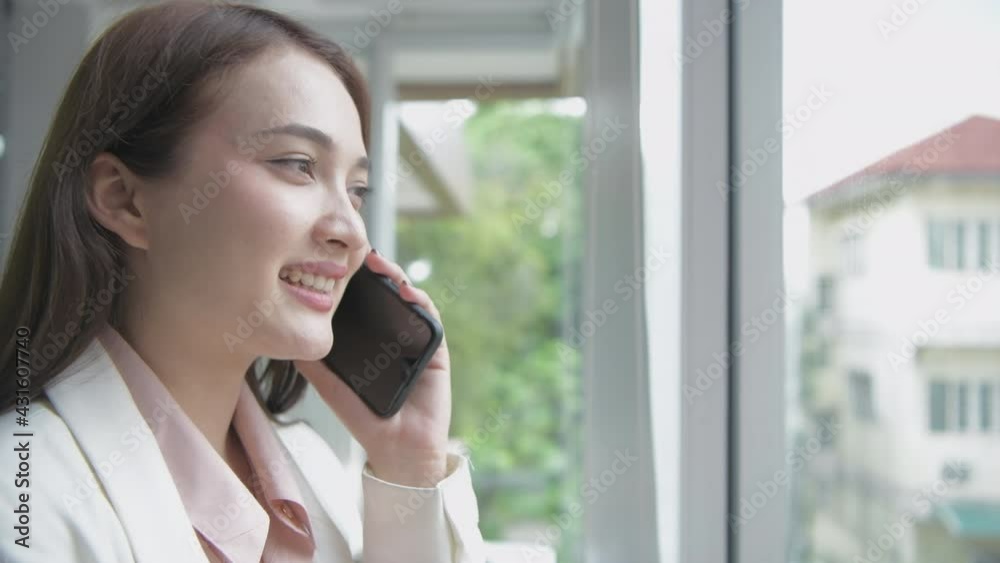 Business concept of 4k Resolution. Asian girls are happily talking on the phone in the office. Business concept of 4k Resolution. Asian girls are happily talking on the phone in the office.