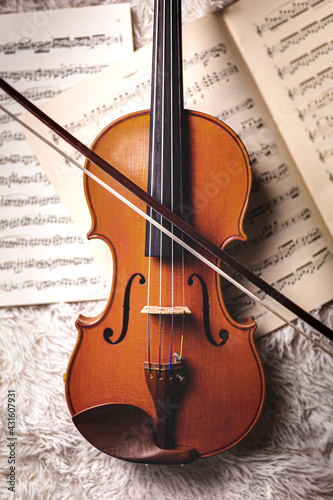 Violin on sheet music with bow