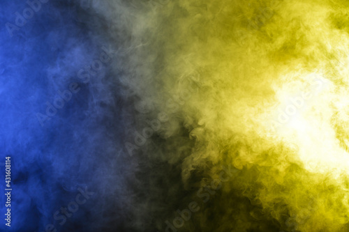 Smoke in blue yellow light on black background