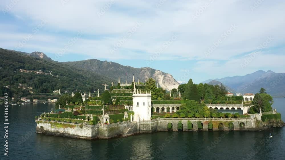 L'île Isola Bella, sa tour et ses jardins dans les Îles Borromées sur le lac Majeur entouré par les montagnes vers Stresa, dans le Piémont, en Italie, en drone et à l'été