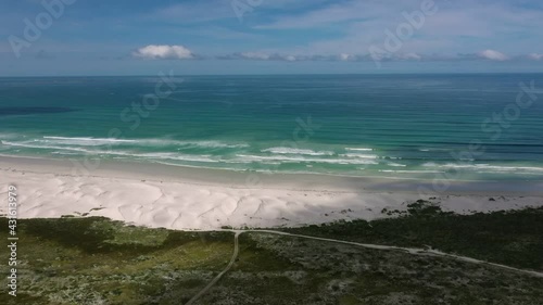 Aerial View Of Beach Coastline With South Atlantic Ocean Waves Breaking. Follow Shot photo