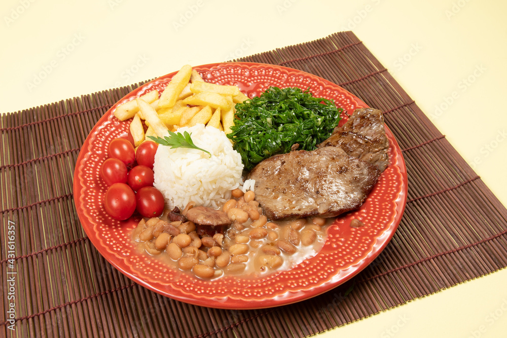 typical Brazilian basic dish with rice, beans, steak, french fries, braised cabbage and tomato typical Brazilian basic dish with rice, beans, steak, french fries, braised cabbage and tomato