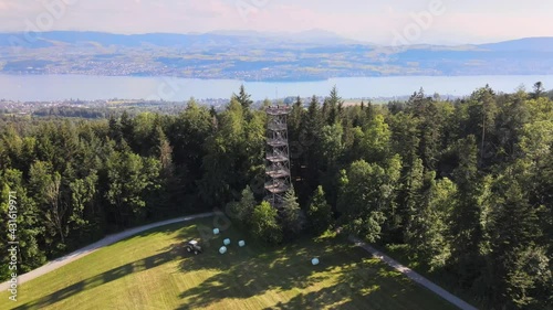 Aerial drone shot flying away showing the Pfannenstiel observation tower and revealing lake Zürich in the background photo