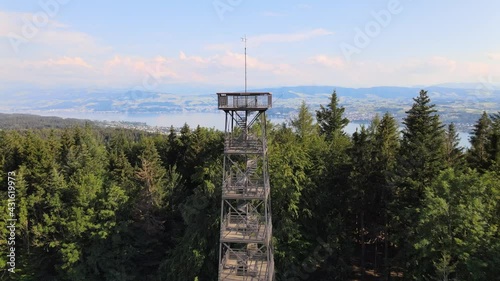 Aerial drone shot flying up and over Pfannenstiel observation tower and revealing lake Zürich in the background photo