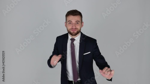 Young handsome businessman in suit smiling, zoomed, isolated, grey background