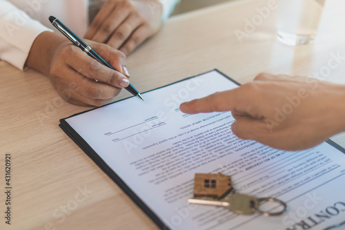 Deal done apartment landlord, banker or realtor man pointing on rent contract renter, tenant or client sign signature on document, paper. Finance,financial of property, estate mortgage or home loan