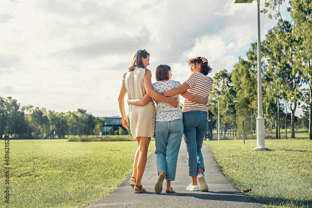 Three women friends with happiness emotion walking in the park hugging each otjher and smiling joyful. Three women friends with happiness emotion walking in the park hugging each otjher and smiling joyful.