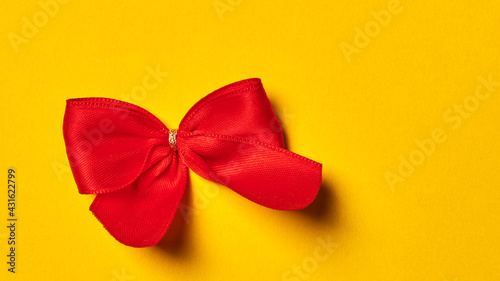 red bow lies on a yellow background