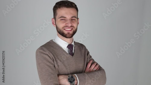 young manager with expensive watch looking at camera and smiling, wearing a brown sweatshirt