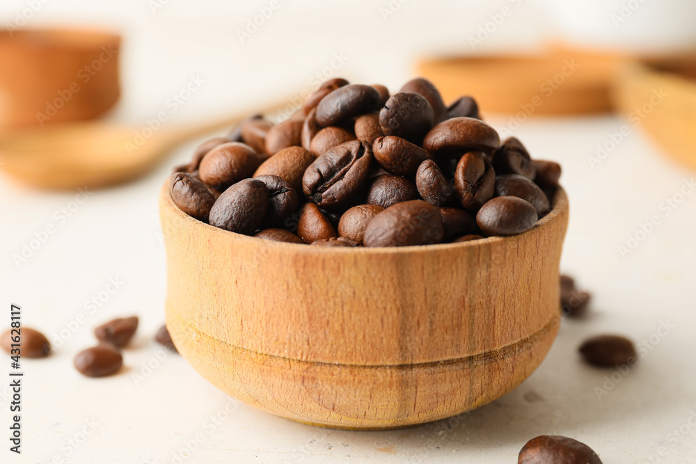 Bowl with coffee beans on light background - obrazy, fototapety, plakaty 