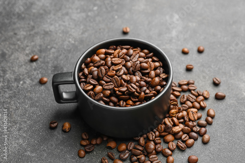 Cup of coffee beans on dark background