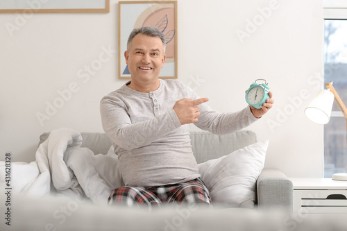 Mature man with alarm clock...