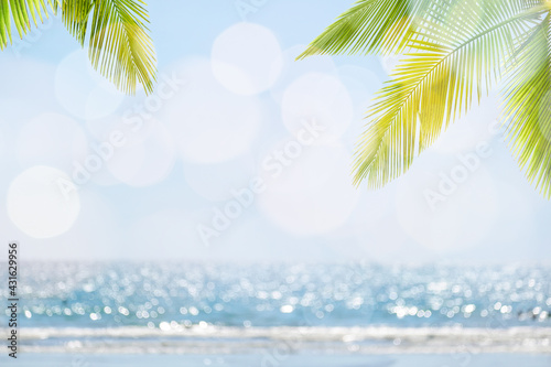 Fototapeta Naklejka Na Ścianę i Meble -  Abstract seascape with palm tree, tropical beach background. blur bokeh light of calm sea and sky. summertime vacation background concept.