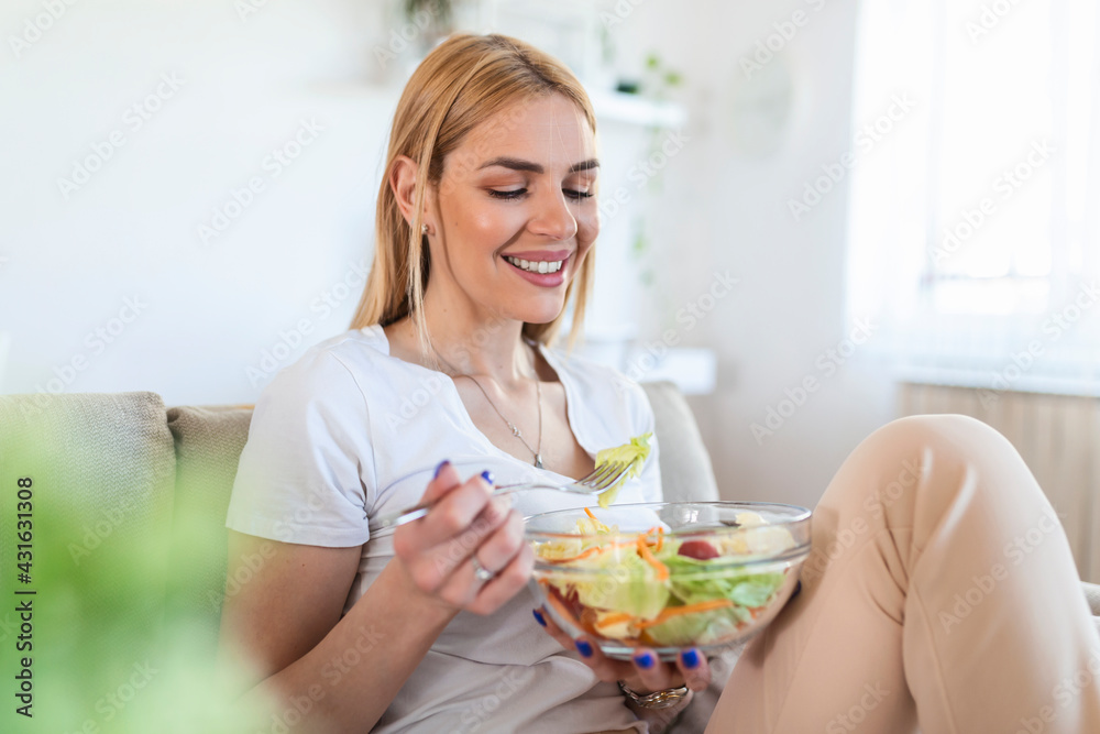 Portrait of attractive caucasian smiling woman eating salad. woman eating healthy salad with tomatoes cherry indoors Healthy lifestyle