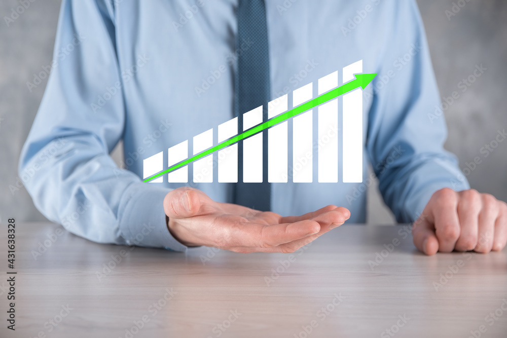 Businessman man holding a graph with positive profits growth. plan graph growth and increase of chart positive indicators in his business.more profitable and growing Businessman man holding a graph with positive profits growth. plan graph growth and increase of chart positive indicators in his business.more profitable and growing