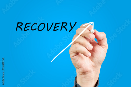 Hand of man drawing an arrow going up next to the word Recovery