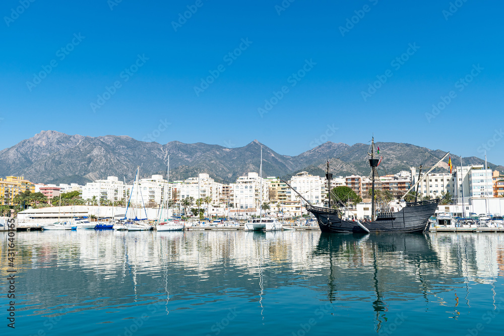 a black pirate style ship docked in the fishing port of Marbella, Spain 