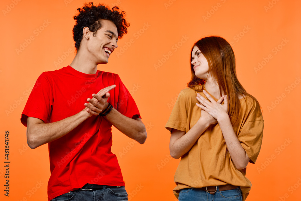 Fototapeta premium cheerful young couple lifestyle studio orange background cropped view