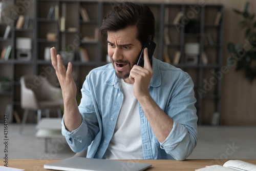 Fotografie Angry irritated man talking on phone, dissatisfied customer arguing or complaini
