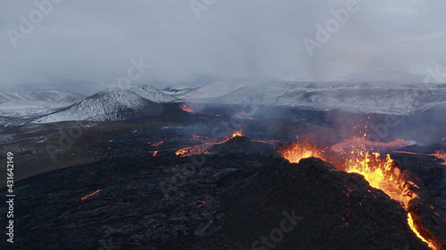 lava eruption volcano with snowy mountains, Aerial view Hot lava and magma coming out of the crater, April 2021 