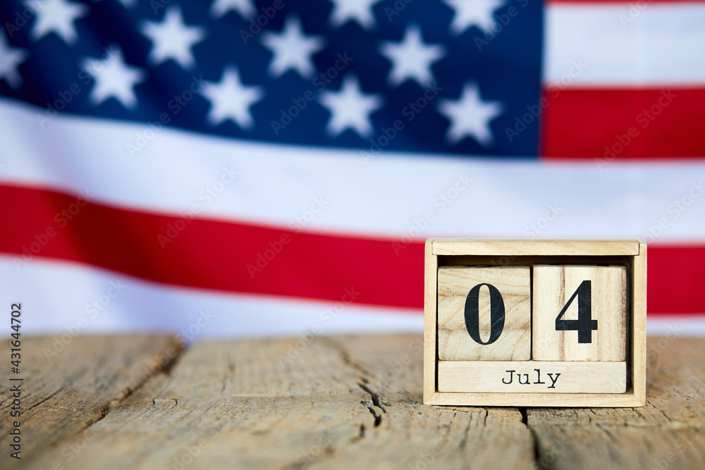 Obraz premium Wooden calendar with date on the background of the USA flag. Template for writing the dates of the national holidays of America with free text space. Independence of United State of America