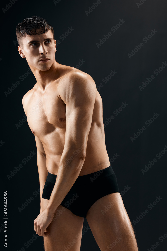 Naklejka premium man pumped up body workout bodybuilder dark background