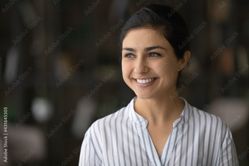Head shot smiling dreamy confident Indian woman looking to aside, successful businesswoman visualizing new opportunities, happy attractive young female dreaming about good future, lost in thoughts