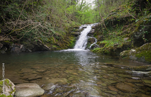 beautiful waterfall in green forest on a spring day, in high Tuscany land, Italy