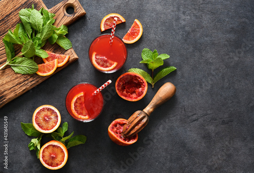 Red orange juice with mint on a black concrete background..Summer drink. Top view.