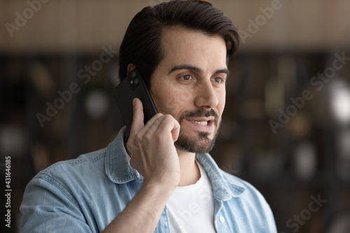 Close up smiling man talking on smartphone, answering or making call, chatting with friend, enjoying pleasant conversation, confident businessman discussing project with colleague by phone