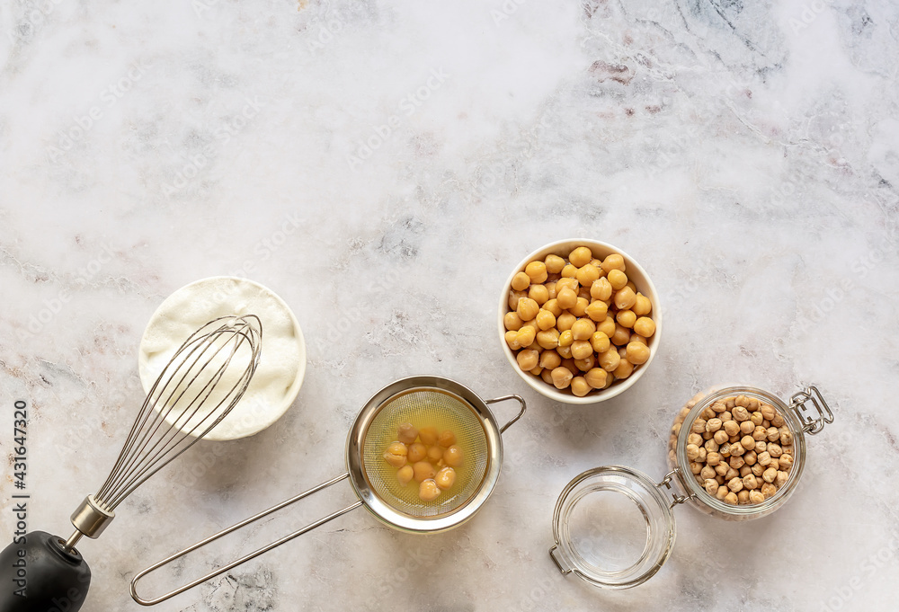 Canned chickpea water aquafaba. Egg replacement and substitutes. Vegan, sustainable lifestyle, and natural eco-friendly products. marble table, copy space, Canned chickpea water aquafaba. Egg replacement and substitutes. Vegan, sustainable lifestyle, and natural eco-friendly products. marble table, copy space,