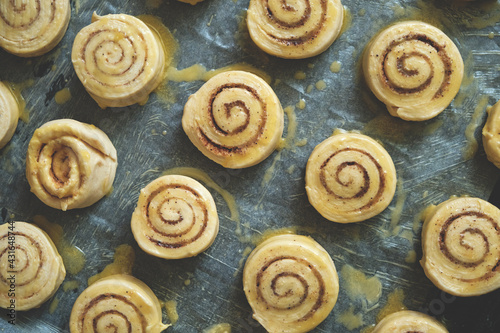 Blanks for baking cinnamon rolls on baking sheet with parchment paper.