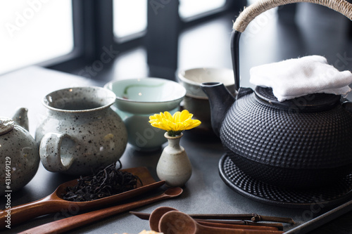 Asian food background with a tea set, cups, tea leaves, and teapot.