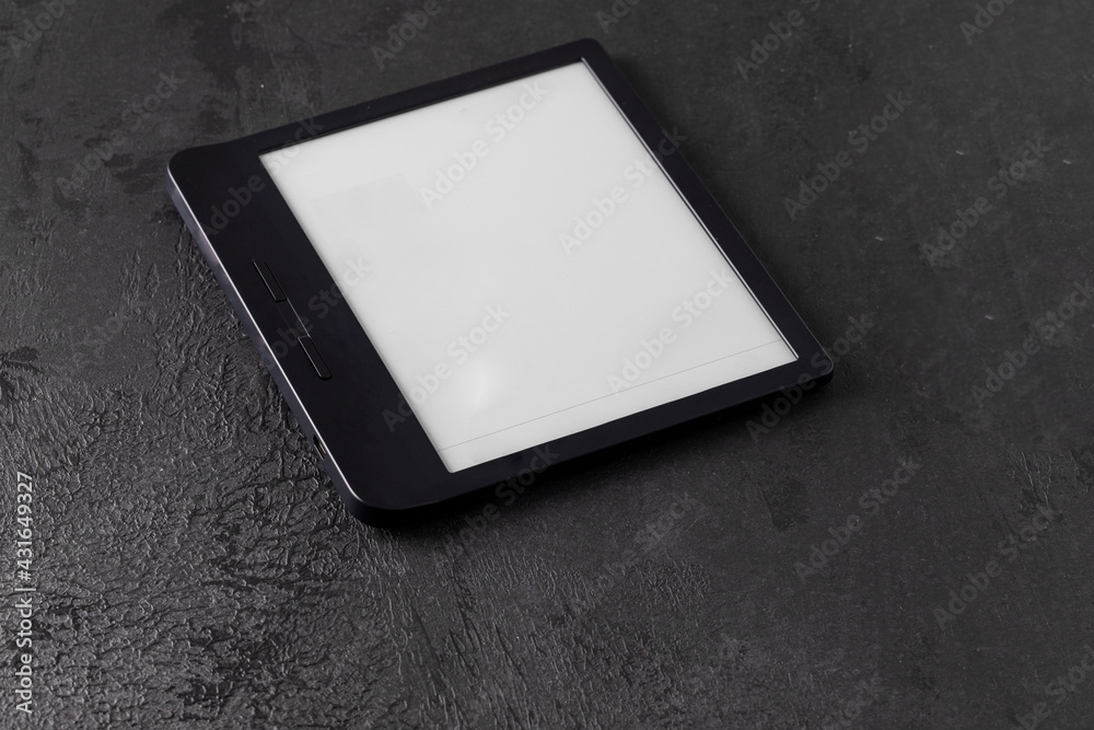 E-book reader on dark cocrete background. Concept for modern reading.Copy space E-book reader on dark cocrete background. Concept for modern reading.Copy space