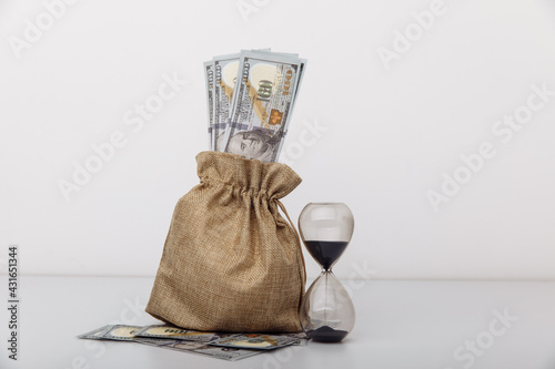 Hourglass with money bag on white background. Time to invest concept