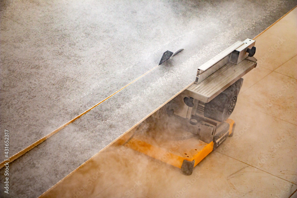 male hands of construction worker sawing and cutting parts of electric miter saw from wooden board. wood board cutting process with blade rotation and dusty cloud electric miter saw male hands of construction worker sawing and cutting parts of electric miter saw from wooden board. wood board cutting process with blade rotation and dusty cloud electric miter saw